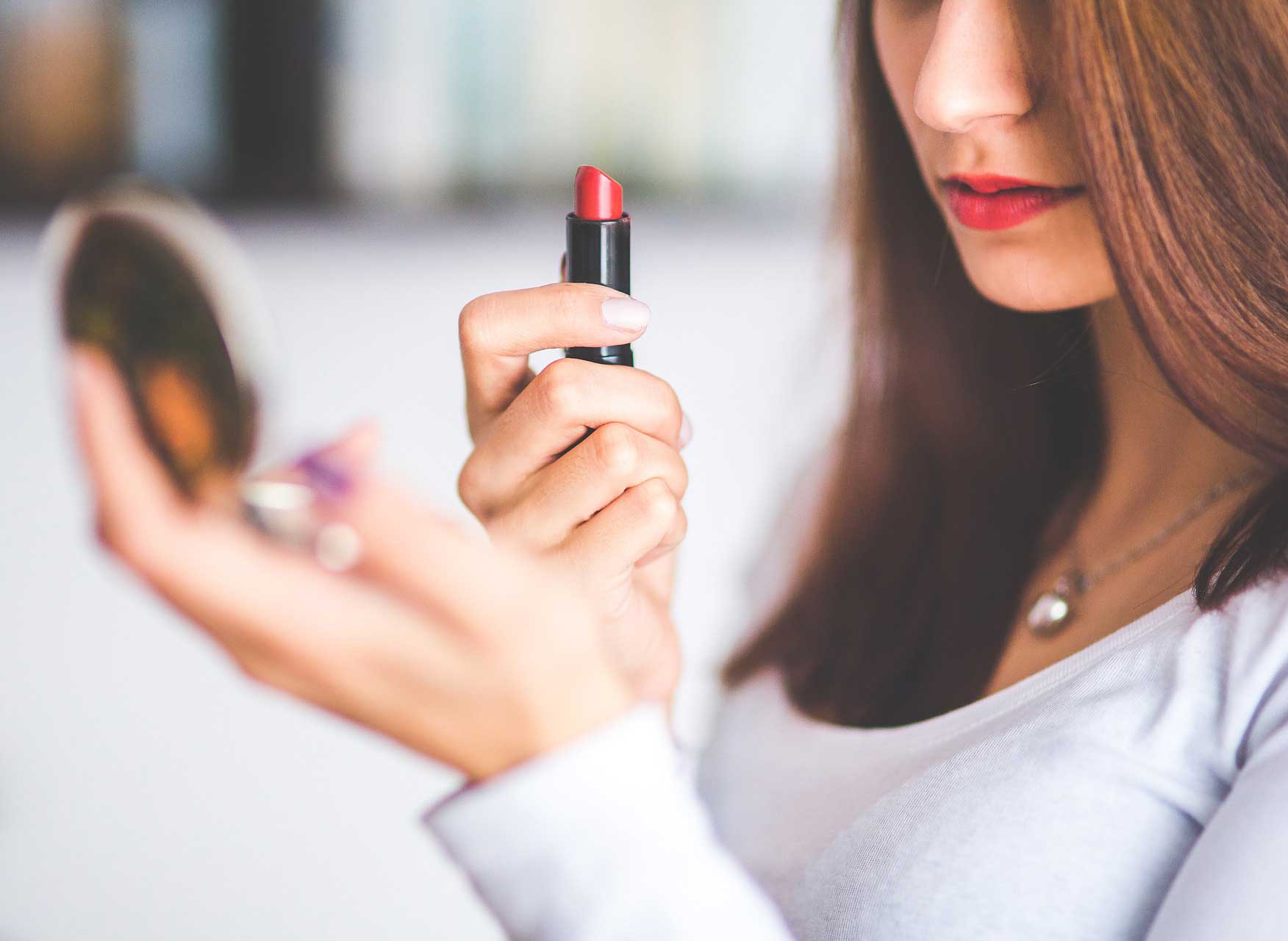 woman-putting-on-lipstick